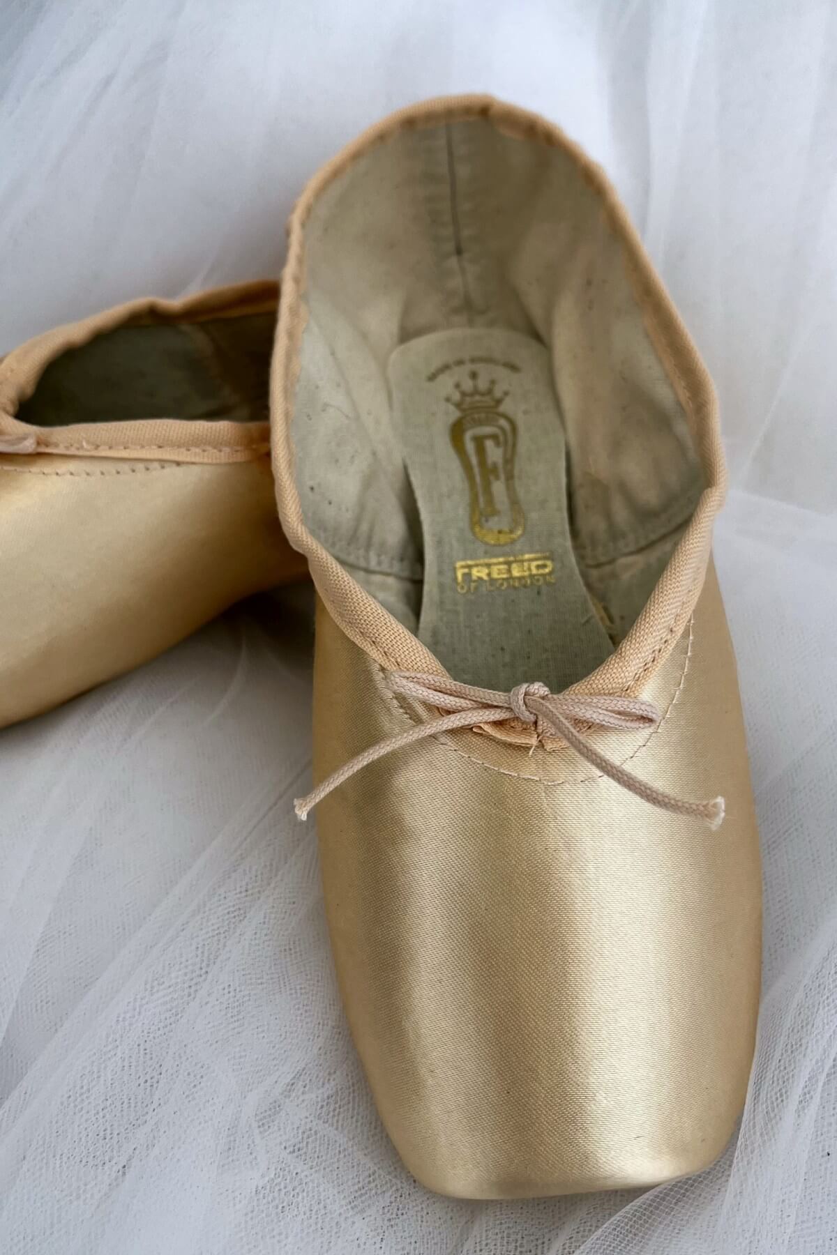 Freed of London Classic Plus Adult Pointe Shoes Front View Чифт балетни палци Freed of London Classic Plus в розов сатен, изгледани отпред върху чист светъл фон.